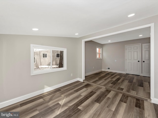 unfurnished room with lofted ceiling and dark hardwood / wood-style floors