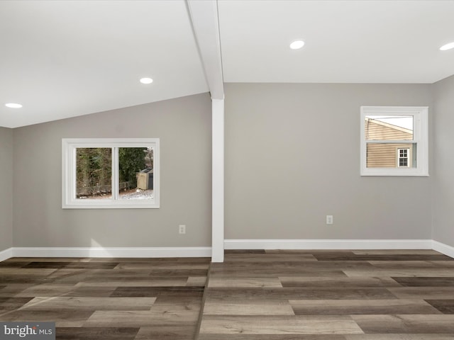 empty room featuring dark hardwood / wood-style floors and lofted ceiling with beams