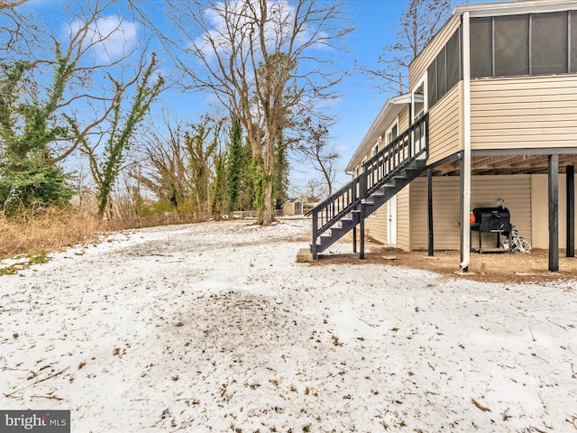 snowy yard featuring a sunroom