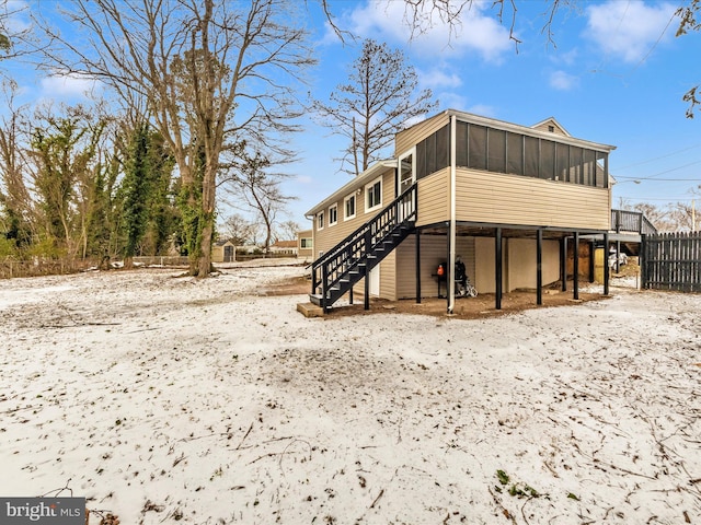 snow covered property with a sunroom