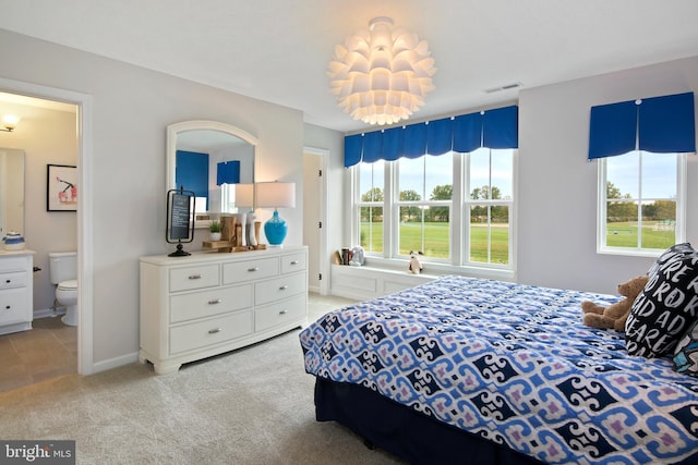 carpeted bedroom featuring ensuite bath