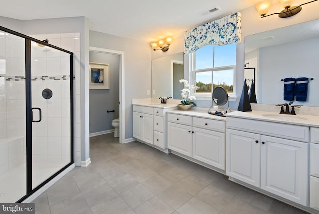 bathroom featuring toilet, a shower with door, and vanity