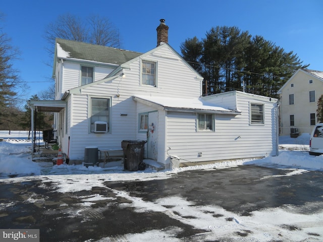 snow covered back of property with central air condition unit