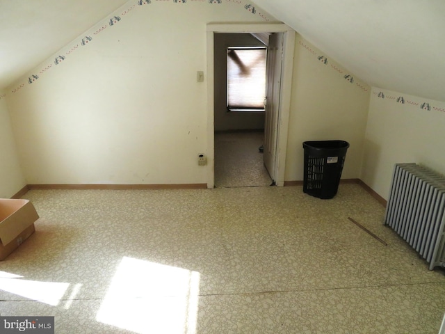 additional living space featuring radiator heating unit and lofted ceiling