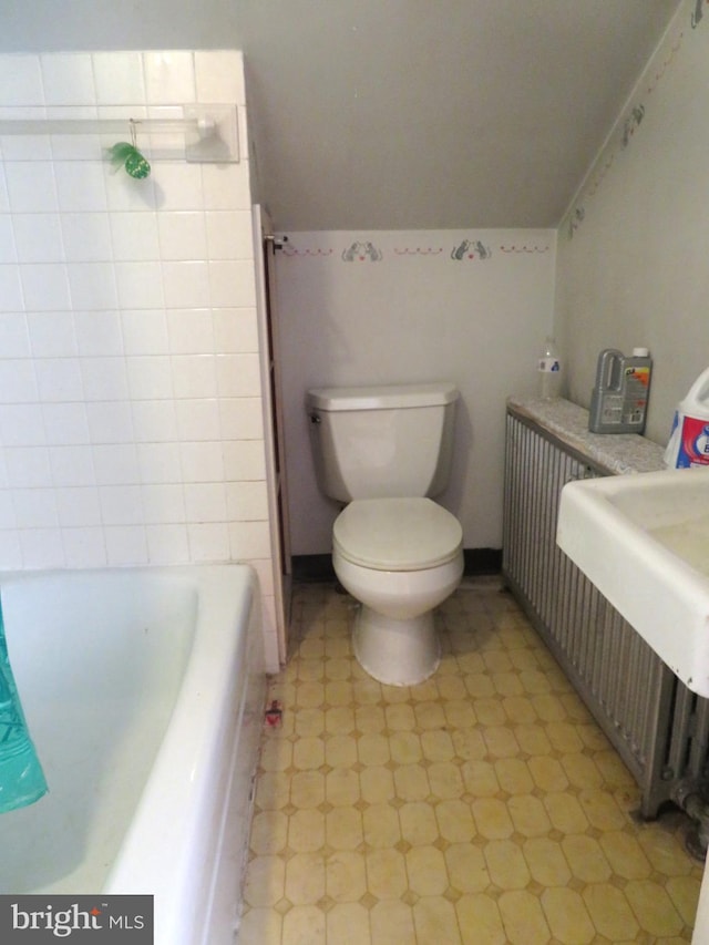 bathroom with a washtub and toilet