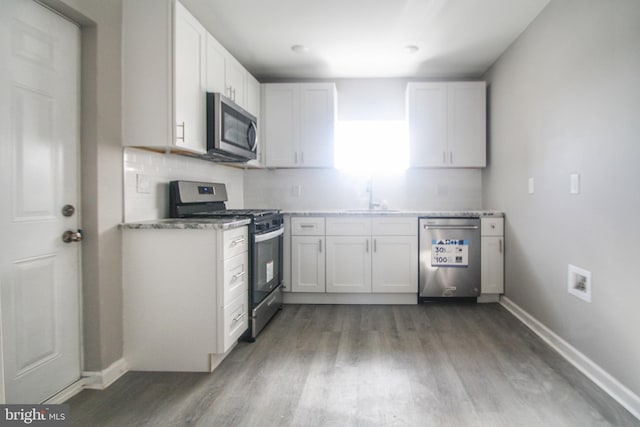 kitchen with stainless steel appliances, dark hardwood / wood-style floors, tasteful backsplash, white cabinets, and sink