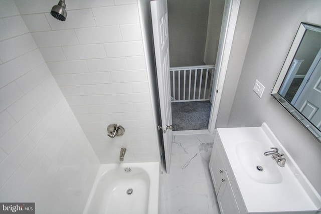 bathroom featuring tiled shower / bath and vanity