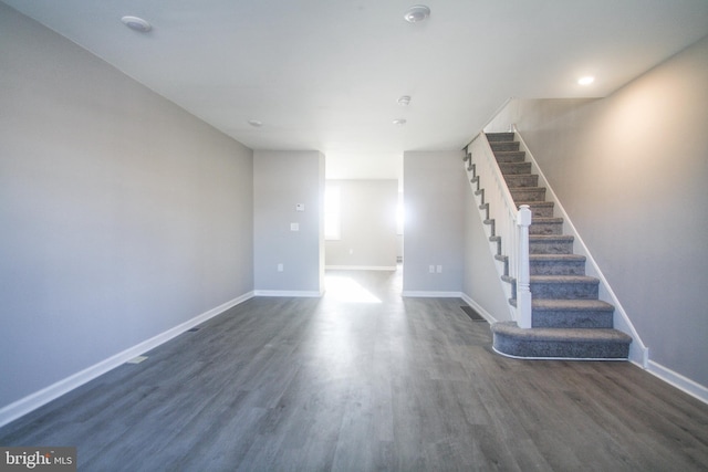 unfurnished living room with dark wood-type flooring