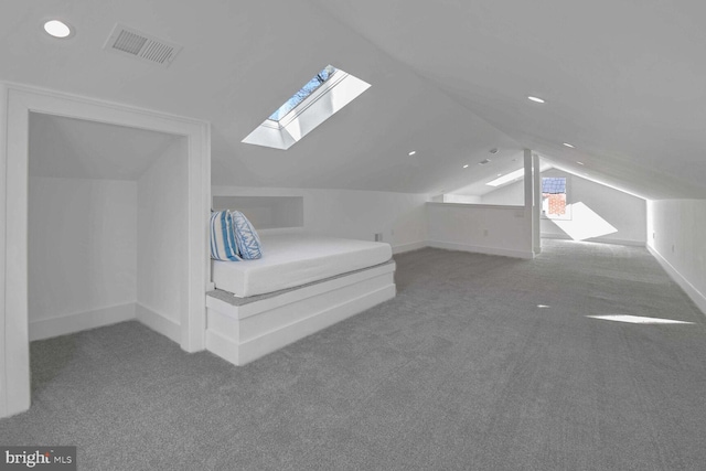 unfurnished bedroom featuring carpet floors and vaulted ceiling with skylight