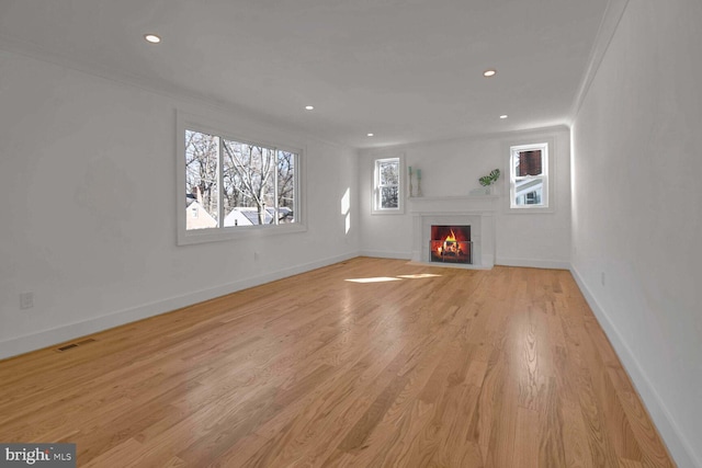 unfurnished living room with crown molding and light wood-type flooring