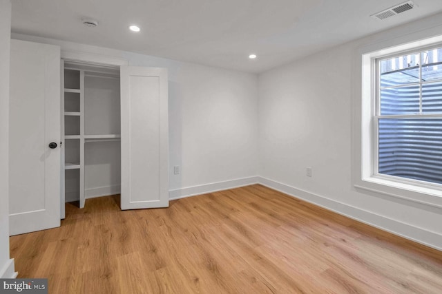 unfurnished bedroom featuring light hardwood / wood-style flooring and a closet