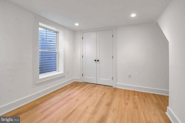 unfurnished bedroom featuring light hardwood / wood-style floors and a closet