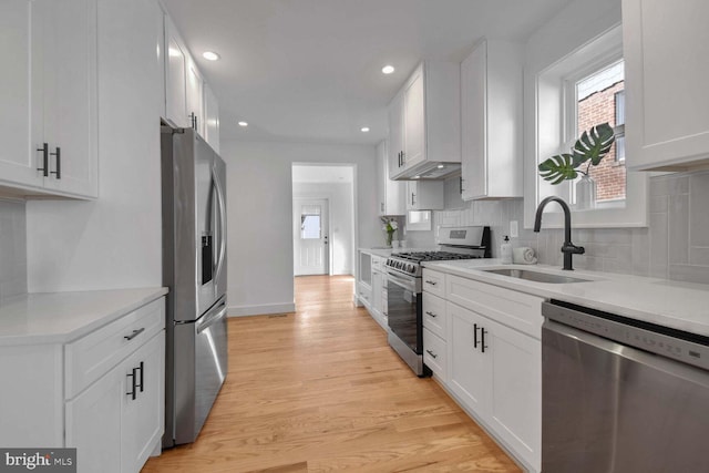 kitchen featuring stainless steel appliances, white cabinetry, sink, and decorative backsplash