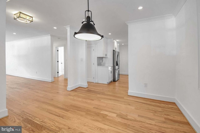 unfurnished living room featuring light hardwood / wood-style flooring and ornamental molding