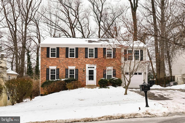 colonial home with a garage and central AC