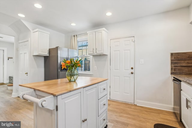 kitchen featuring stainless steel refrigerator with ice dispenser, white cabinetry, butcher block countertops, and light wood-type flooring