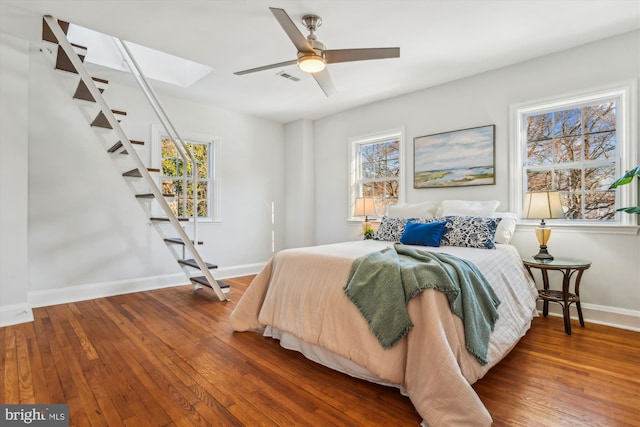 bedroom with hardwood / wood-style flooring, ceiling fan, and multiple windows