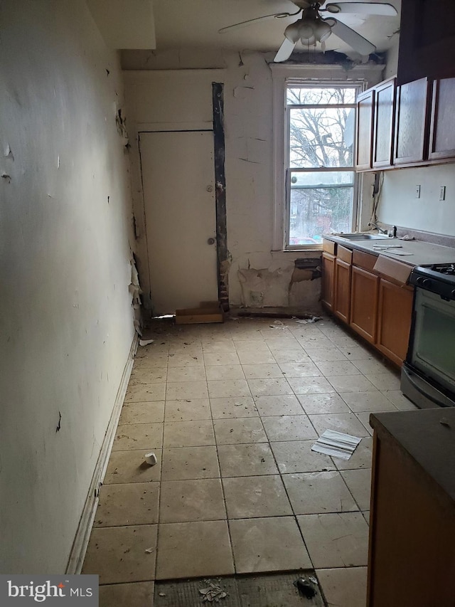 kitchen featuring ceiling fan, sink, and gas range