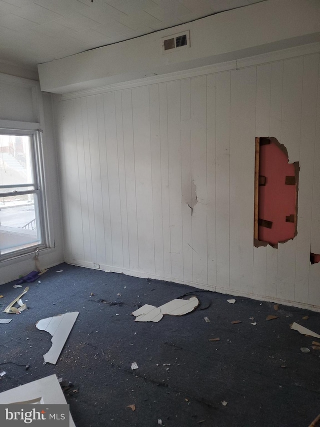 spare room featuring wooden walls