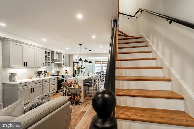 stairway with hardwood / wood-style flooring and sink