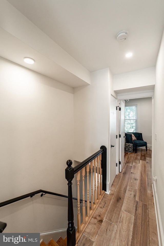 corridor with hardwood / wood-style flooring