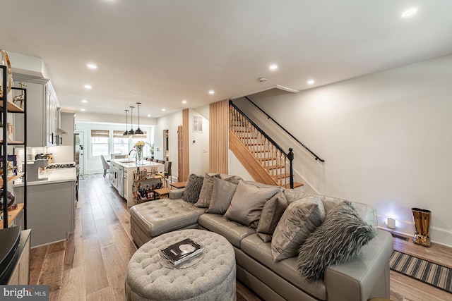 living room with sink and light hardwood / wood-style flooring