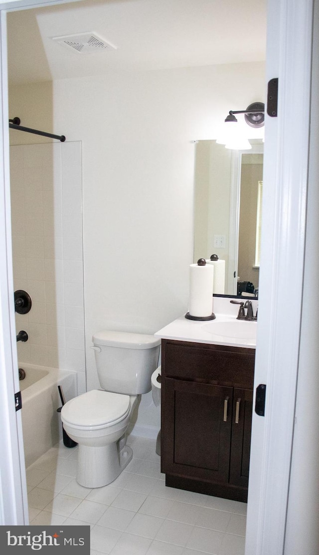 full bathroom with tiled shower / bath, vanity, toilet, and tile patterned floors