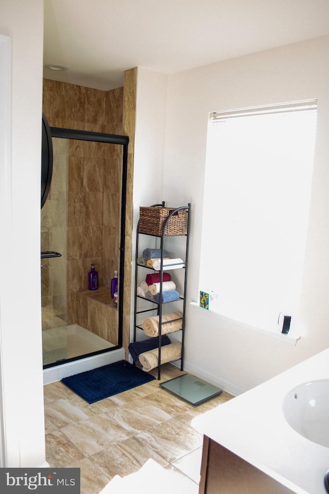 bathroom with an enclosed shower, vanity, and plenty of natural light