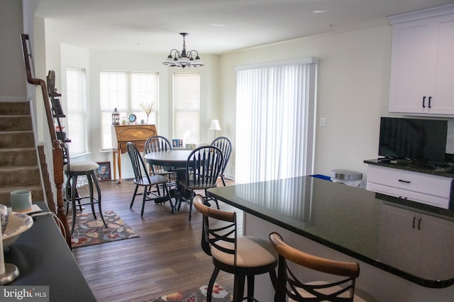 dining room with dark hardwood / wood-style floors and an inviting chandelier