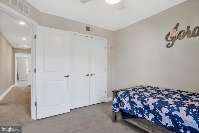 carpeted bedroom featuring ceiling fan and a closet