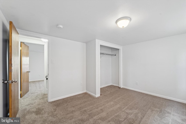 unfurnished bedroom featuring a closet and light colored carpet