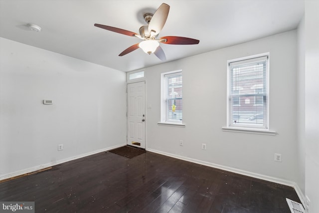 unfurnished room featuring ceiling fan, dark hardwood / wood-style floors, and a wealth of natural light