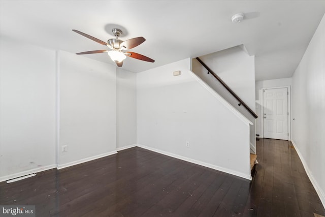 unfurnished living room featuring ceiling fan and dark hardwood / wood-style flooring