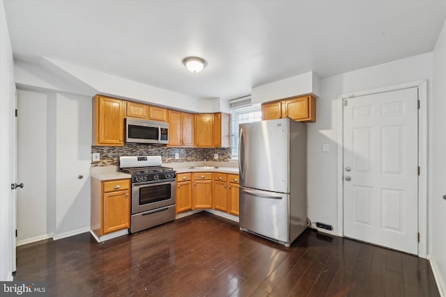 kitchen featuring dark hardwood / wood-style flooring, appliances with stainless steel finishes, and decorative backsplash