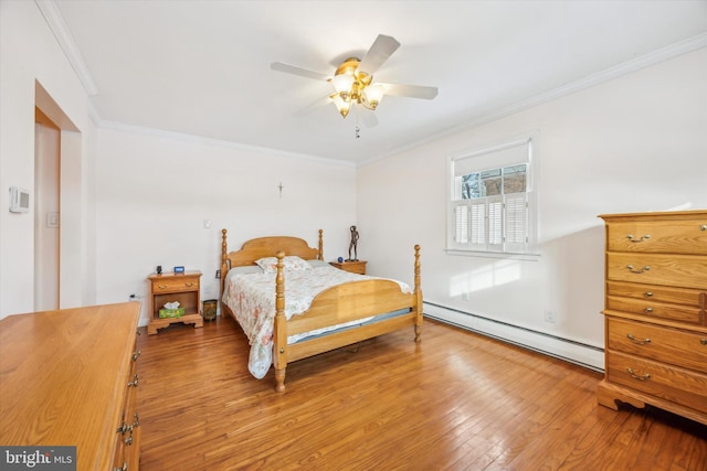 bedroom featuring ceiling fan, a baseboard radiator, hardwood / wood-style floors, and crown molding