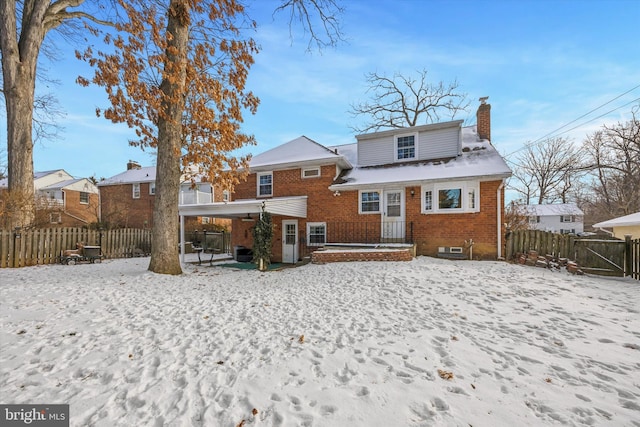 view of snow covered back of property