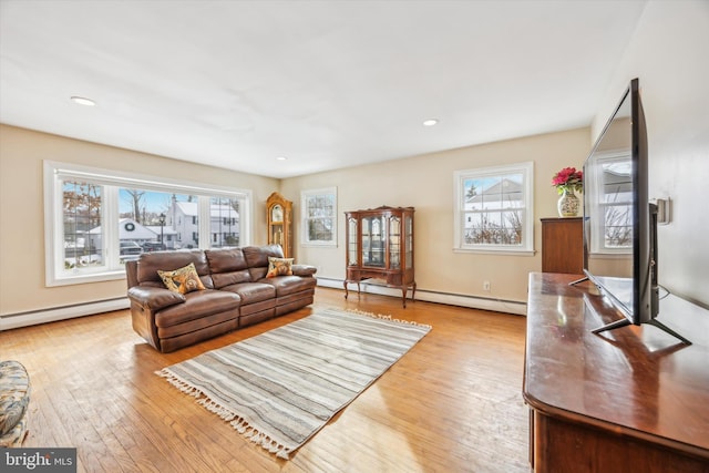 living room featuring a baseboard heating unit and light hardwood / wood-style flooring