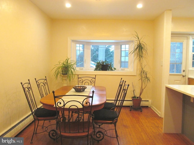 dining space with hardwood / wood-style floors and baseboard heating