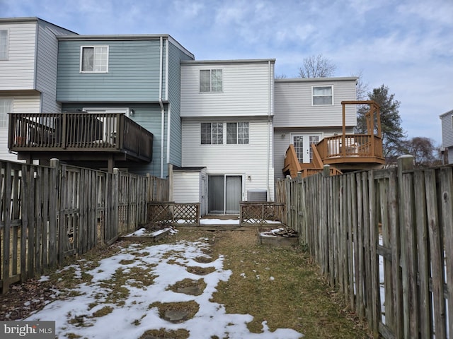 snow covered house with a wooden deck