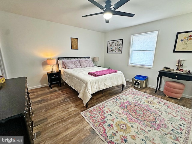 bedroom featuring wood finished floors, a ceiling fan, and baseboards