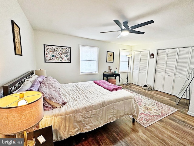 bedroom featuring ceiling fan, two closets, and wood finished floors