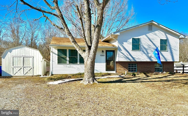 tri-level home featuring a storage unit and a front lawn