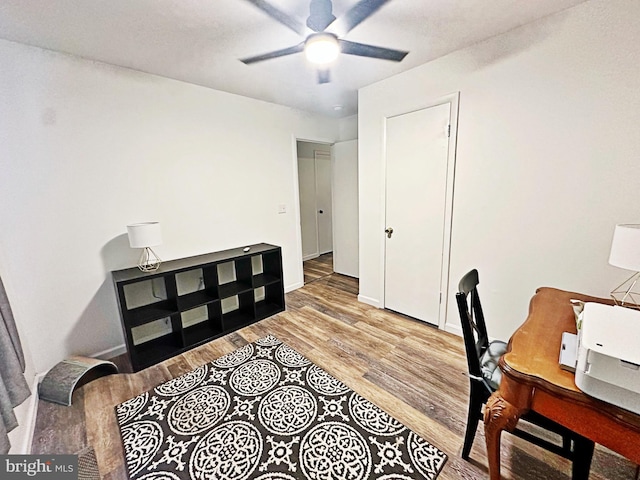 office space featuring ceiling fan, baseboards, and wood finished floors