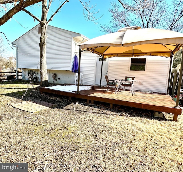 rear view of house featuring a gazebo and a deck