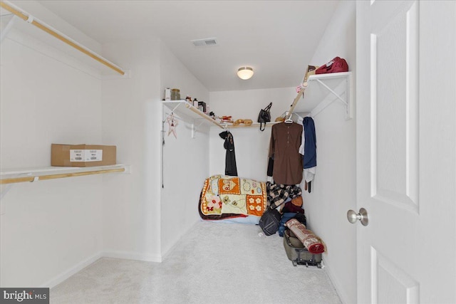 walk in closet featuring light carpet