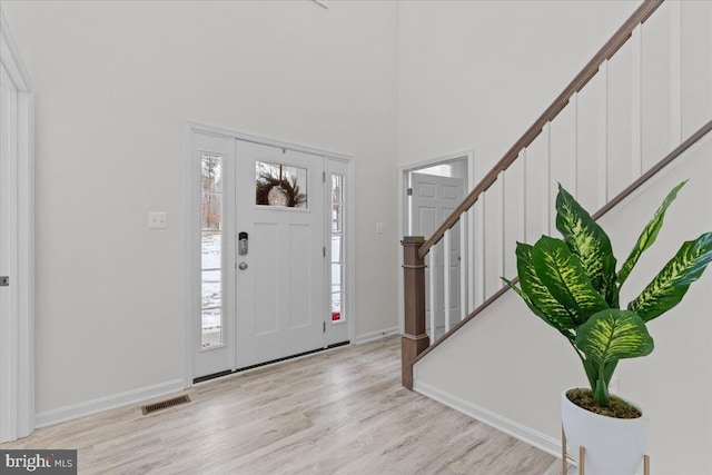 foyer featuring light wood-type flooring and a high ceiling