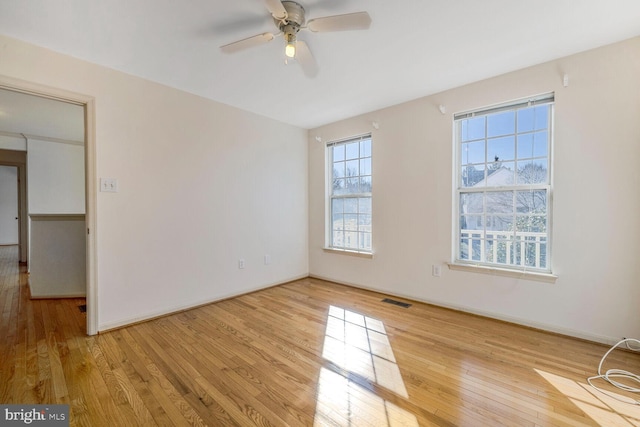 empty room with ceiling fan and light hardwood / wood-style flooring