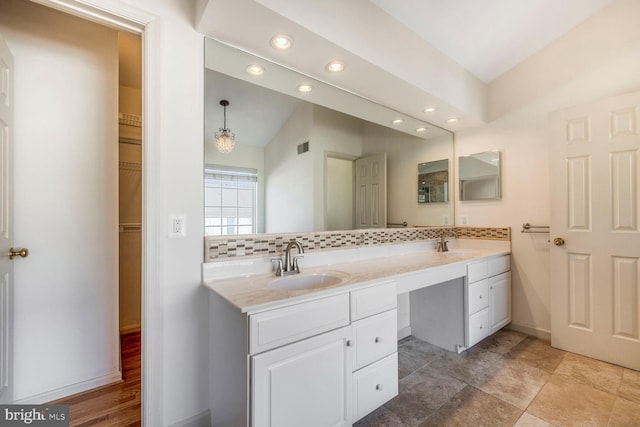 bathroom with tasteful backsplash and vanity