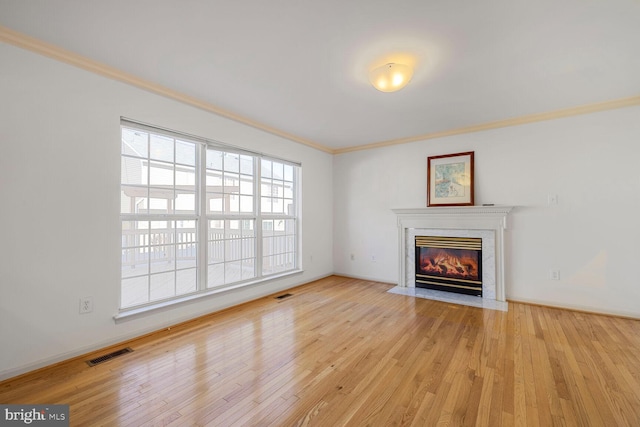 unfurnished living room with crown molding, light hardwood / wood-style flooring, and a premium fireplace