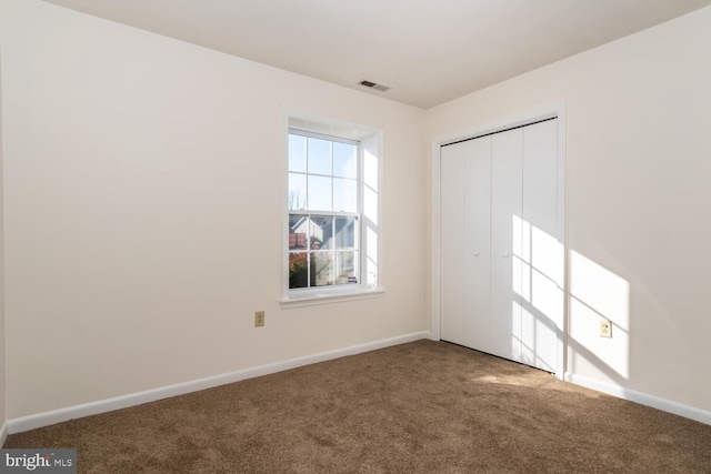 unfurnished bedroom with carpet flooring and a closet